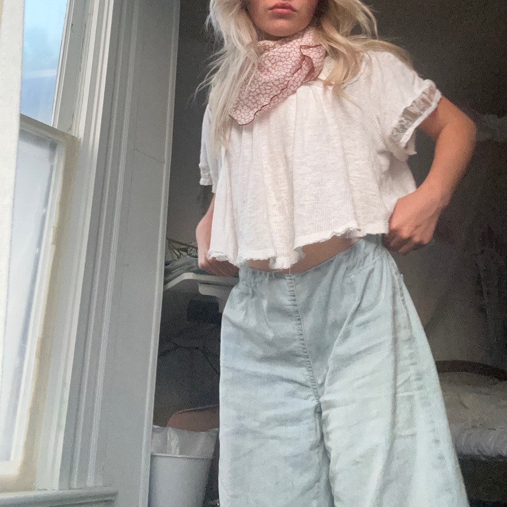 Free People off-white short sleeve crop with lacy bodice and raw hem.